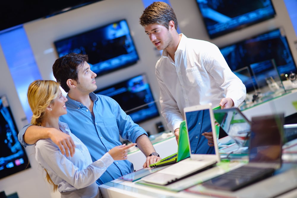 people in consumer electronics  retail store looking at latest laptop, television and photo camera to buy